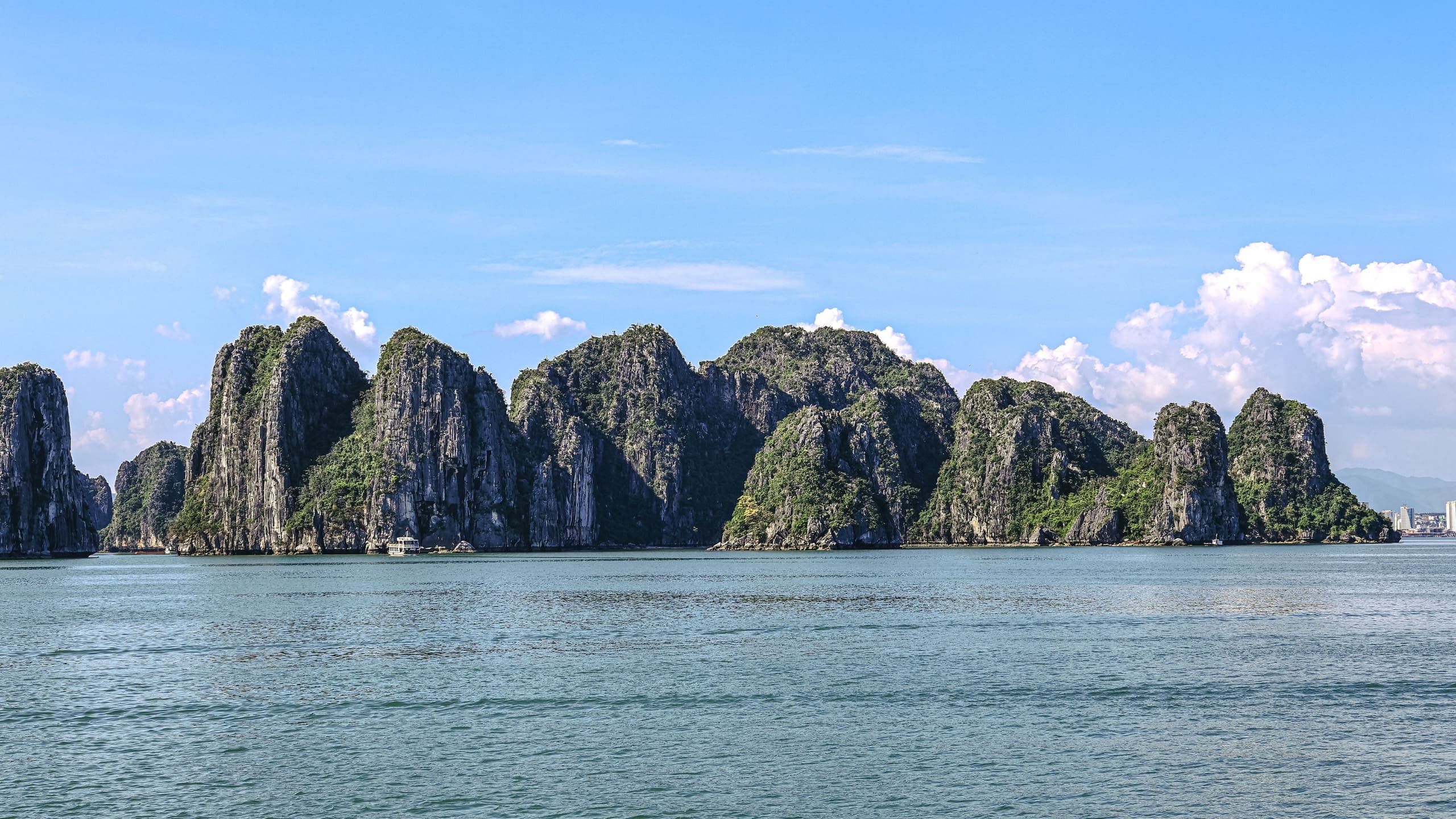 Limestone islands in Ha Long Bay, Vietnam, beneath a blue sky
