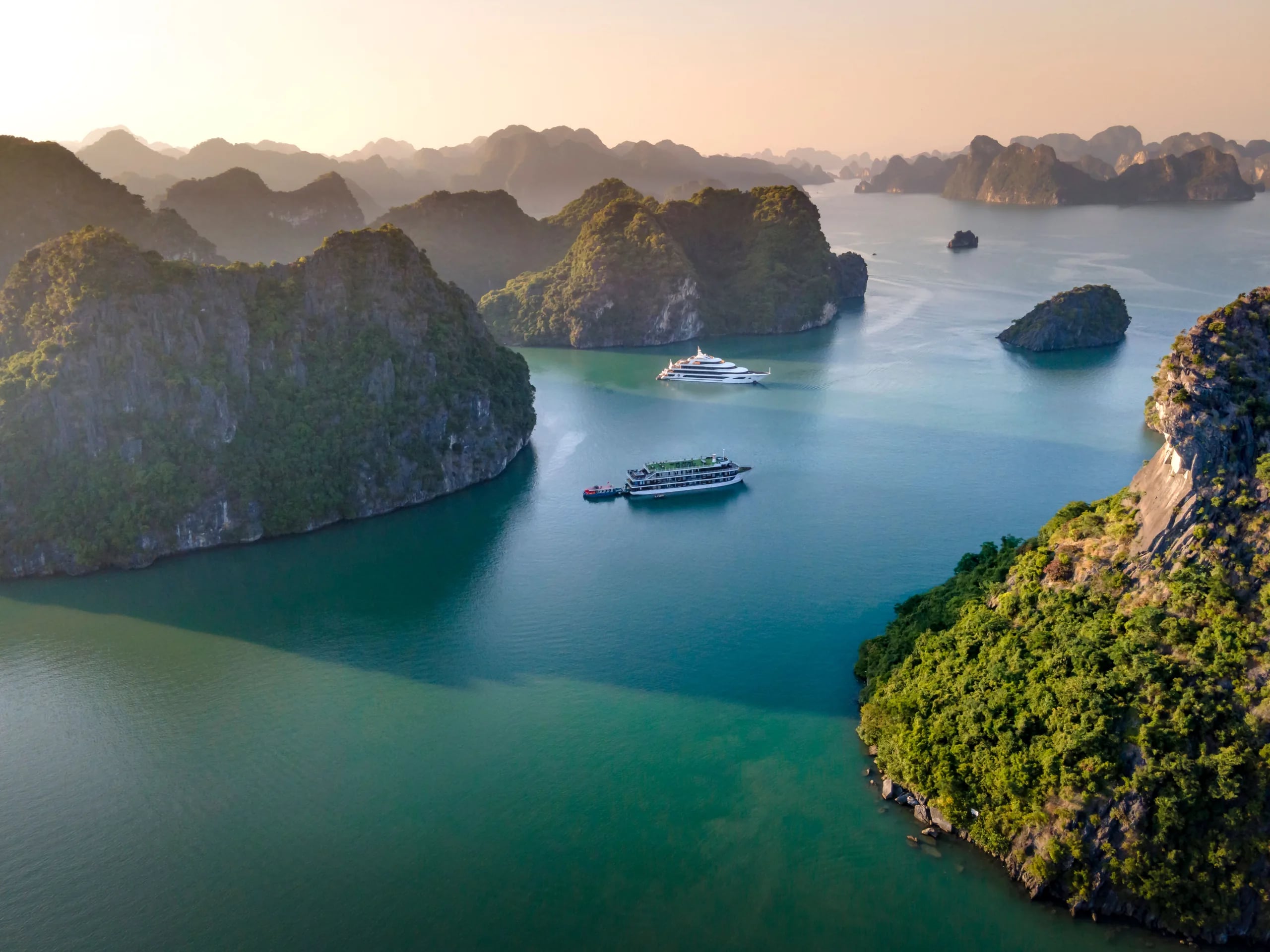Limestone islands and boats on the emerald waters of Ha Long Bay, Vietnam